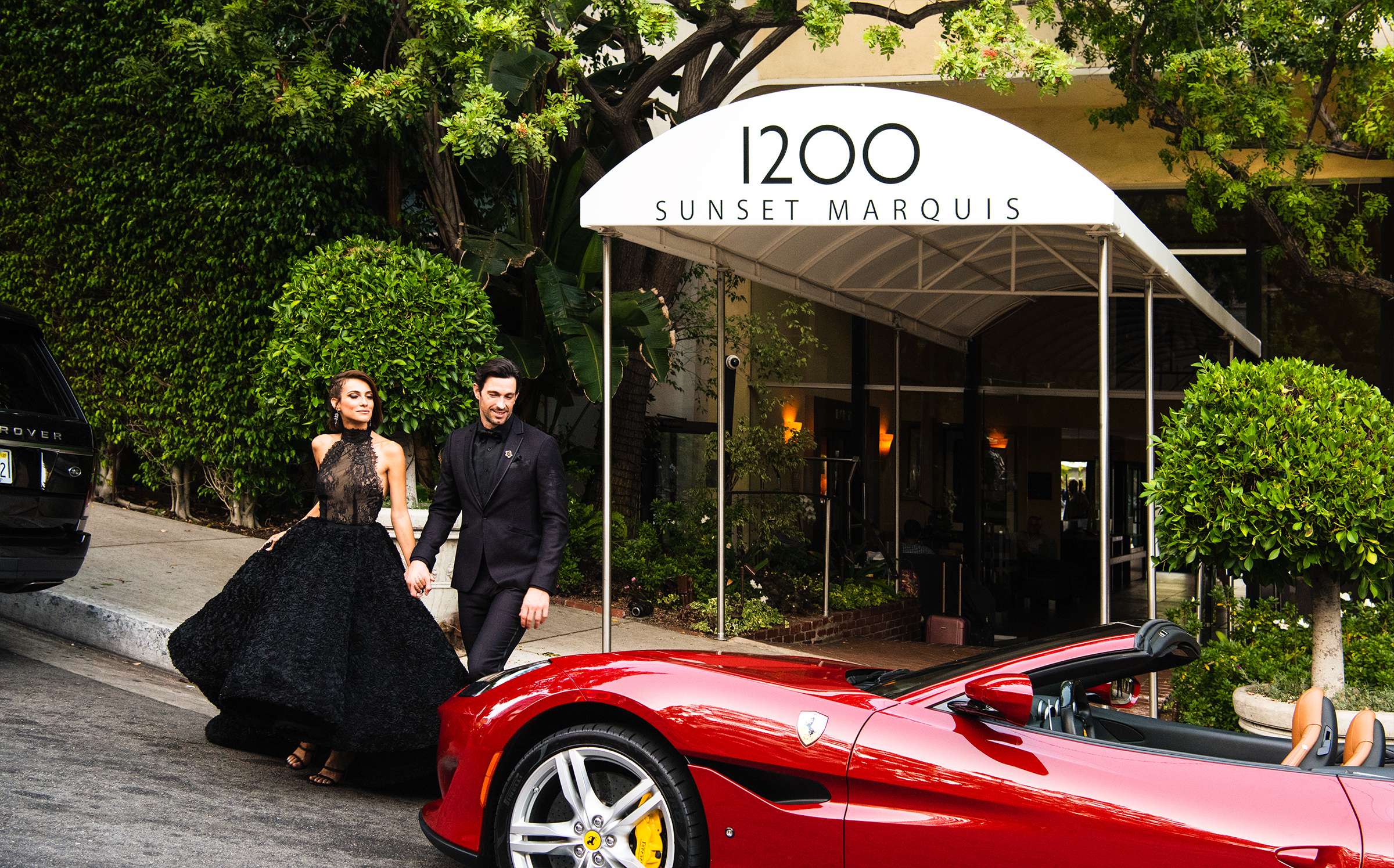 Sunset Marquis valet greeting beside a red Ferrari at the hotel entrance