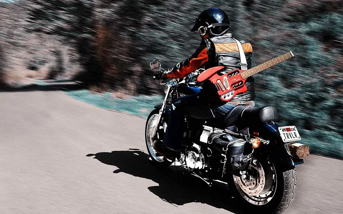 Traveler Guitar strapped to a motorcycle on the road